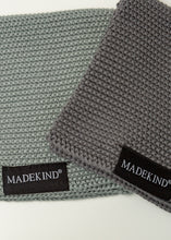 Load image into Gallery viewer, Photo of two grey madekind cloths with the logos on the front
